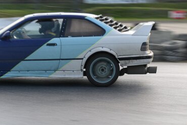 BMW 3er (E36) Limousine blau-weiß in Action